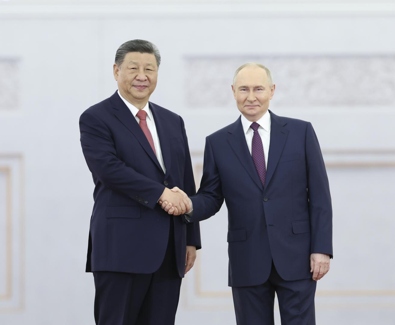 習近平與普京親切握手。（新華社）
