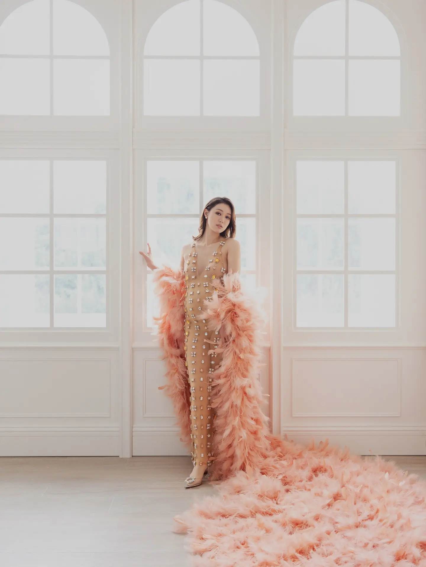 張寶兒身穿裸色 Deep V 連身裙，外搭粉紅色毛毛披肩，驟眼看有透視錯覺，配上 3 寸高跟鞋，四肢依舊纖瘦，僅圓碌碌的巨肚格外顯眼。。(圖：Bowie Cheung 張寶兒@FB)