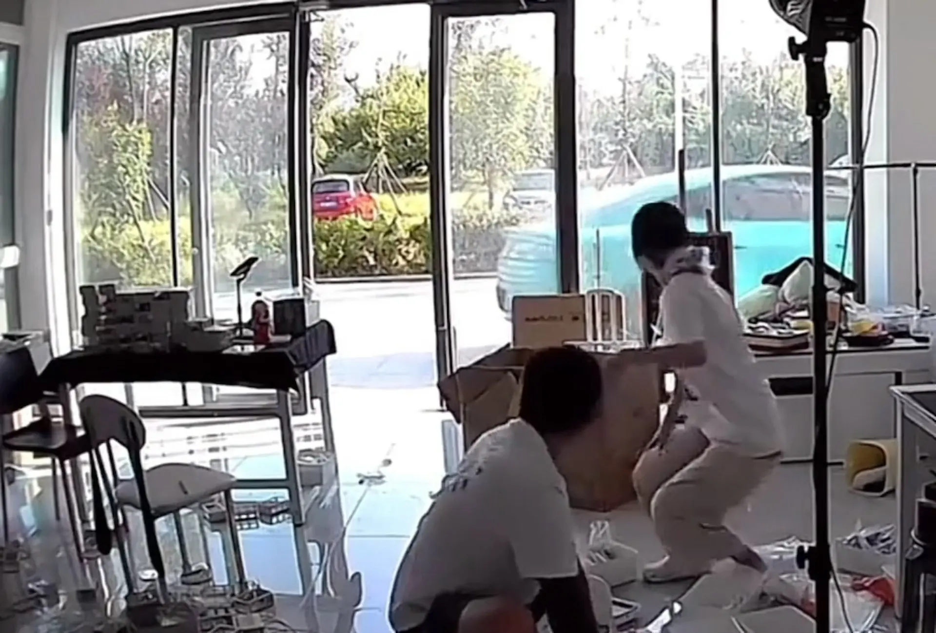 山東威海一名小米車主發布的監控視頻驚動網友，畫面中店門前的水藍色小米汽車突然解鎖鳴笛，隨即自行啟動駛離。​(圖：視頻翻攝)