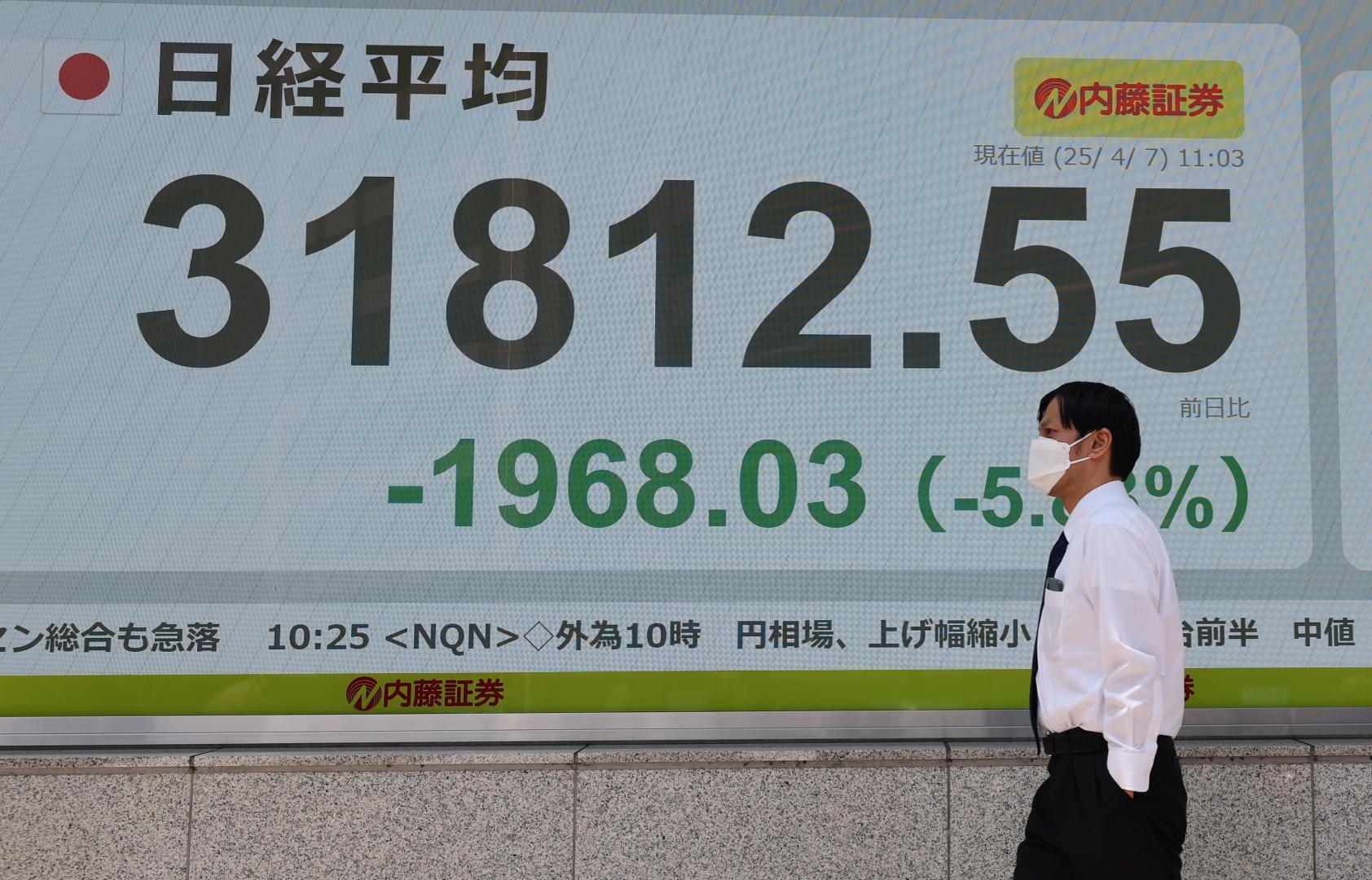 4月7日，行人經過位於日本東京的電子股指顯示器。（新華社）