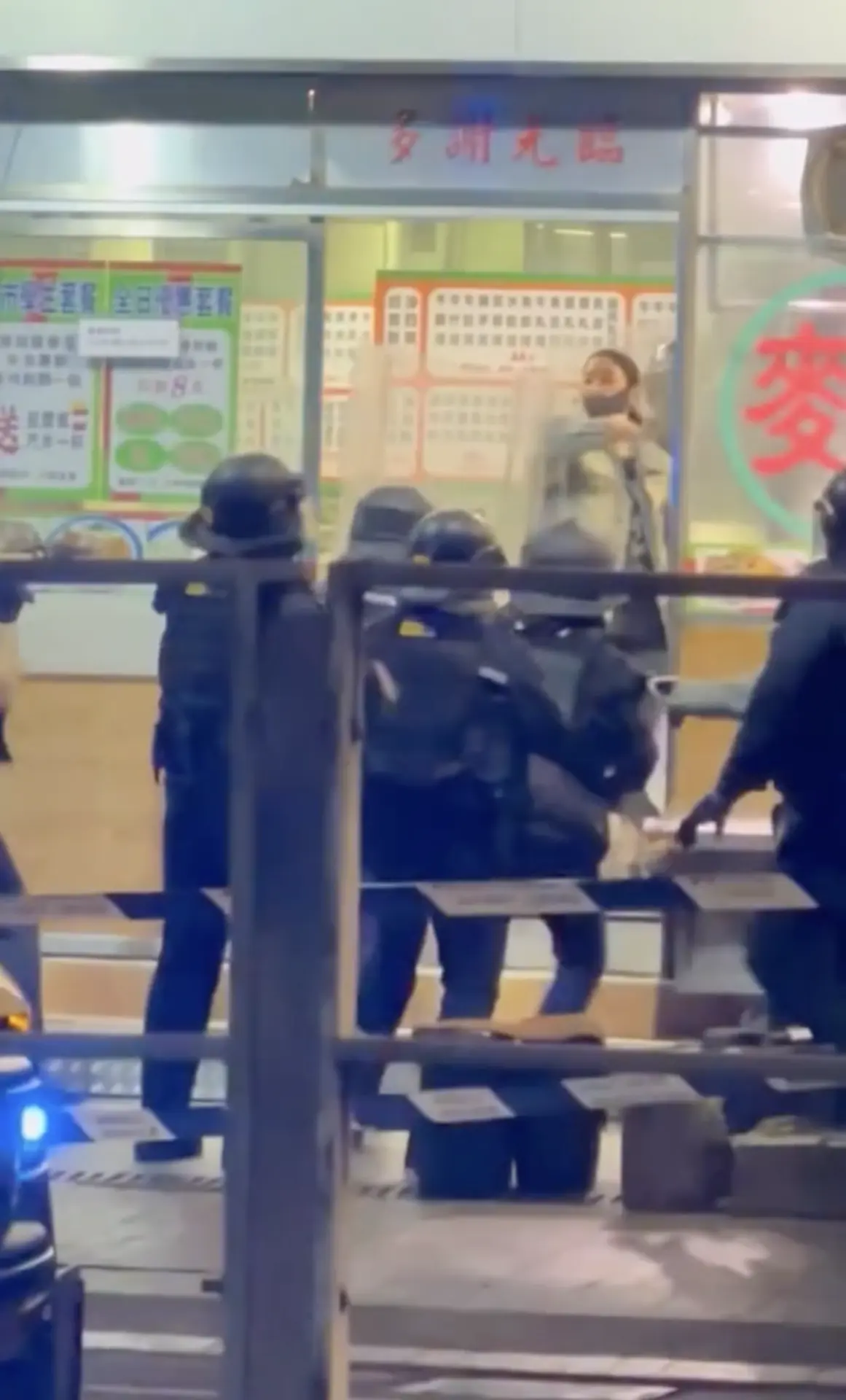 其後，另一批警員從店舖後門包抄進入，與門前警員形成前後夾攻之勢，最終成功將該女子撳地制服。據目擊者陳先生向媒體透露，他凌晨路經事發店舖時，已見大批警員在場拉起封鎖線，店內職員及其他食客早已疏散離開。(圖：視頻截圖)
