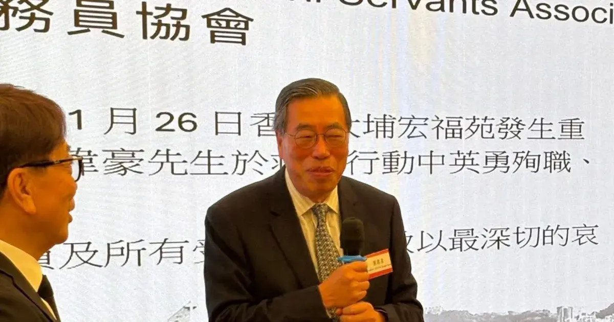 最受關注的是立法會主席梁君彥現身並發言。相片顯示，梁君彥手持無線咪在台上致辭時，背後大螢幕正播放哀悼在大火中殉職的消防員何偉豪名字，惟梁君彥面露笑容，畫面迅速在網上流傳。 (圖：James Chak@FB)