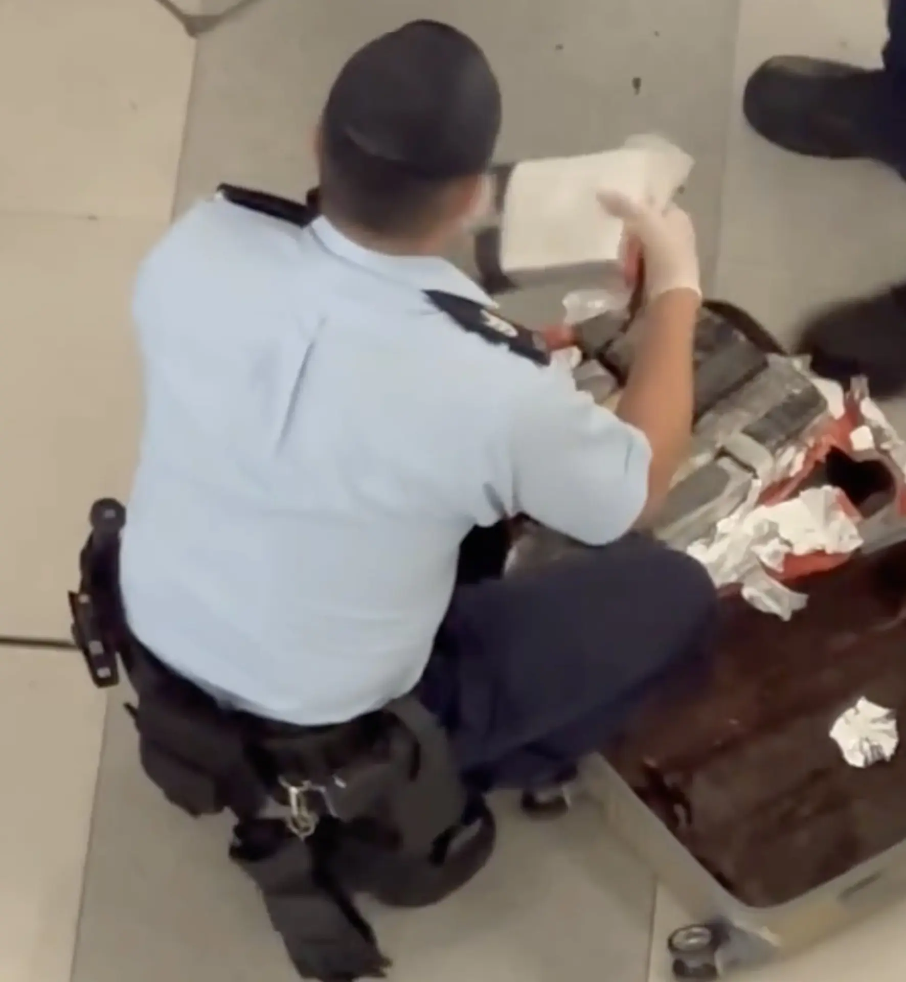 警員當場以鎅刀割開包裝，發現內藏白色磚狀物，懷疑是毒品可卡因，隨即拍照記錄證據，並以透明證物袋逐一封存。(圖：視頻翻攝)