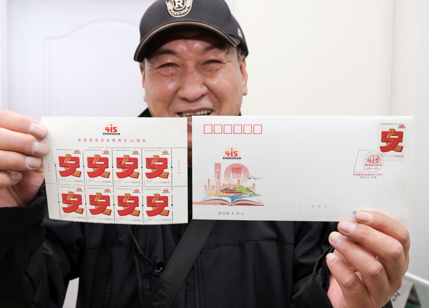 4月15日，郵迷在北京市西城區集郵營業廳展示《全民國家安全教育日10周年》紀念郵票和首日封。