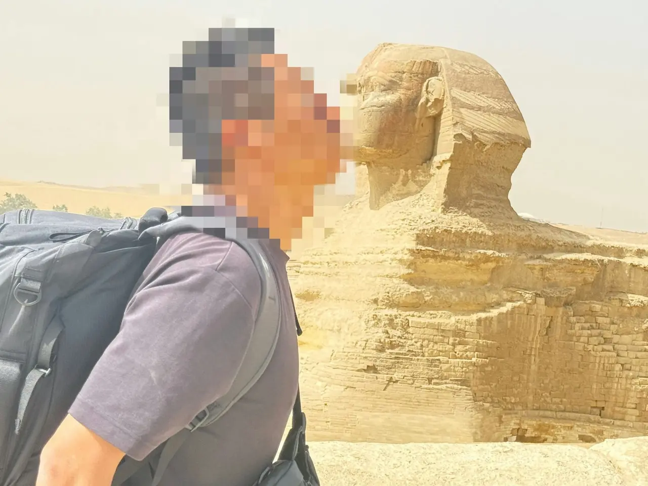 日本旅人Sukiyaki前往埃及人面獅身像打卡，遭持有官方證照的人員熱心幫拍，被誘至無人死角後對方態度驟變，強扣手機勒索費用，事件曝光後引發眾多遊客共鳴與避雷討論。（來源：Thai__Suki@X）