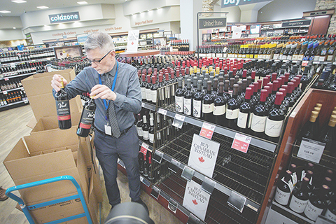 加拿大不列顛哥倫比亞省政府三月十日宣佈下架由不列顛哥倫比亞省酒類分銷局運營的酒類專賣店內所有美國酒類產品，以回應美國政府對加拿大商品加徵百分之二十五關稅的措施。圖為當日，在加拿大溫哥華，一家不列顛哥倫比亞省酒類專賣店的店員從貨架上撤下美國酒類產品。（新華社）