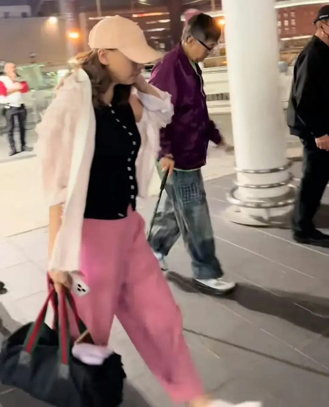 與身旁44歲的女友林子萱對比更為鮮明，林子萱當晚戴著棒球帽，身著黑白搭配粉紅色褲裝，活力充沛地緊隨其後，悉心照料。(圖：香港Jason X@抖音)