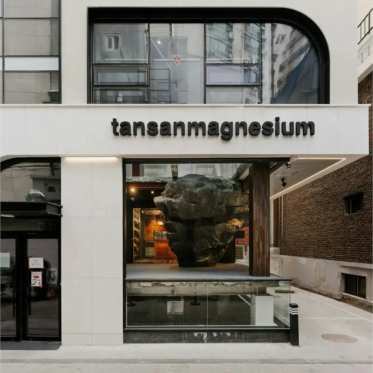 韓國聖水洞服裝店Tansan Magnesium以「攀巖入店」爆紅，保留建築原始巨石當入口，主打輕鬆攀巖理念，旁設一般門，用趣味設計打破大眾對攀巖的困難刻板印象。（來源：tansan magnesium官網）