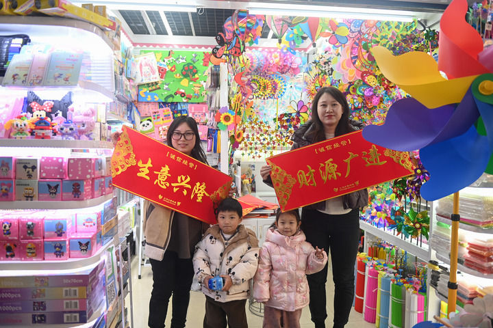 義烏國際商貿城的商戶在店鋪門口展示領取的新春橫幅（新華社)