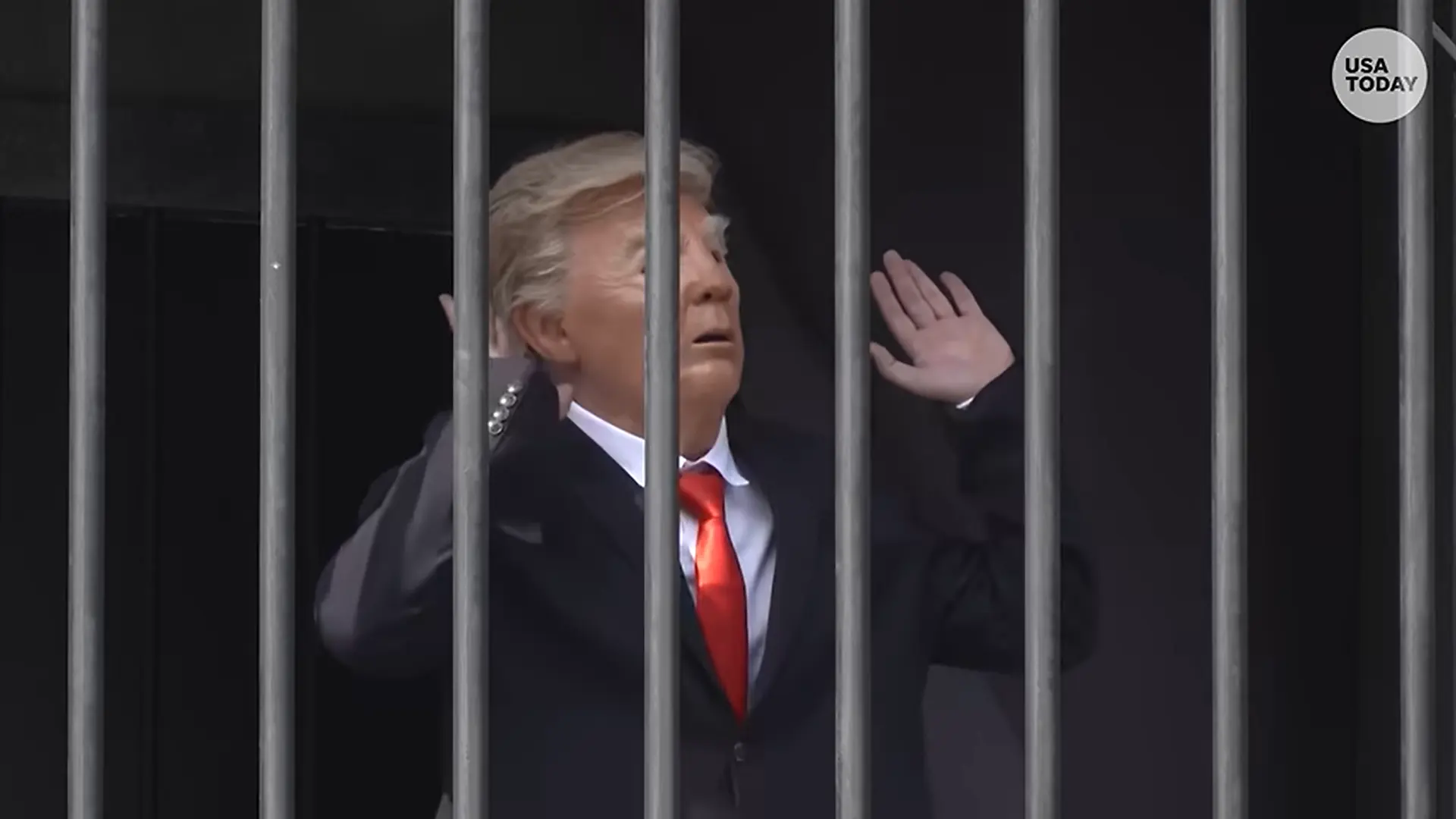德黑蘭塔吉里什廣場半空吊起鐵籠，演員戴特朗普面具扮囚犯踱步、跳「Y.M.C.A.」，旁設銀幕斥美國戰爭罪行，展演15天，引民眾圍觀。（來源：USA TODAY@YouTube）