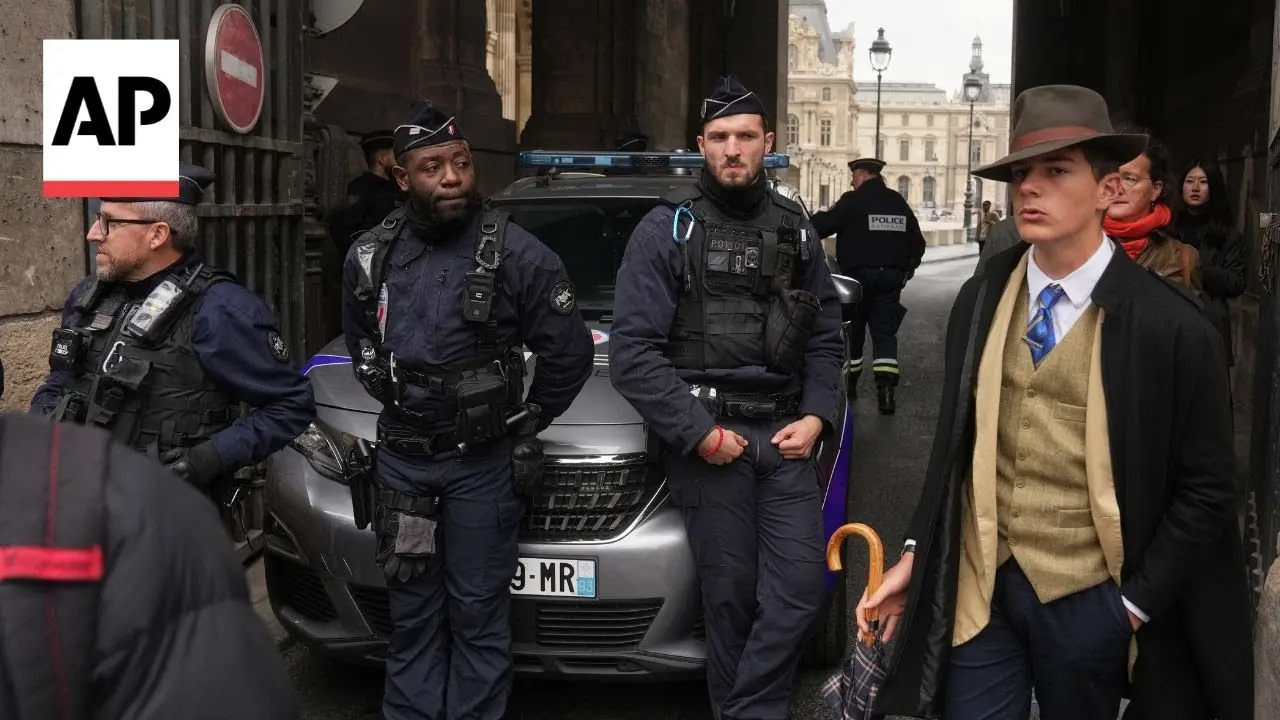 羅浮宮發生7分鐘珠寶竊案後，一張現場照片讓穿復古西裝的15歲少年德爾沃（Pedro Elias Garzon Delvaux）以「費多拉帽男（Fedora Man）」身份爆紅，被誤認成偵探，實則他僅是參觀遇關門，其穿搭靈感源自經典偵探角色。（視頻截圖來源：Associated Press@YouTube）