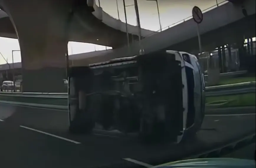 碰撞瞬間，私家車被巴士頂撞後打了個筋斗，翻滾一圈後在往北大嶼山公路出口快線翻側停下，車身橫亘路中，部分汽車殘件散落地上。(圖：車Cam L/ Martin Yeung@FB)