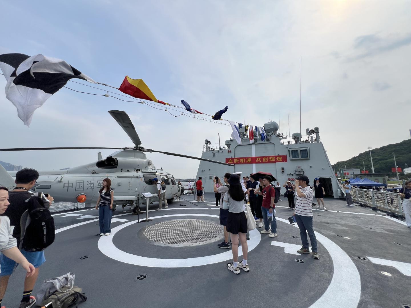 「直-9」艦載直升機停泊在飛行甲板上，吸引不少市民遊客合影留念。(圖:陳杰)