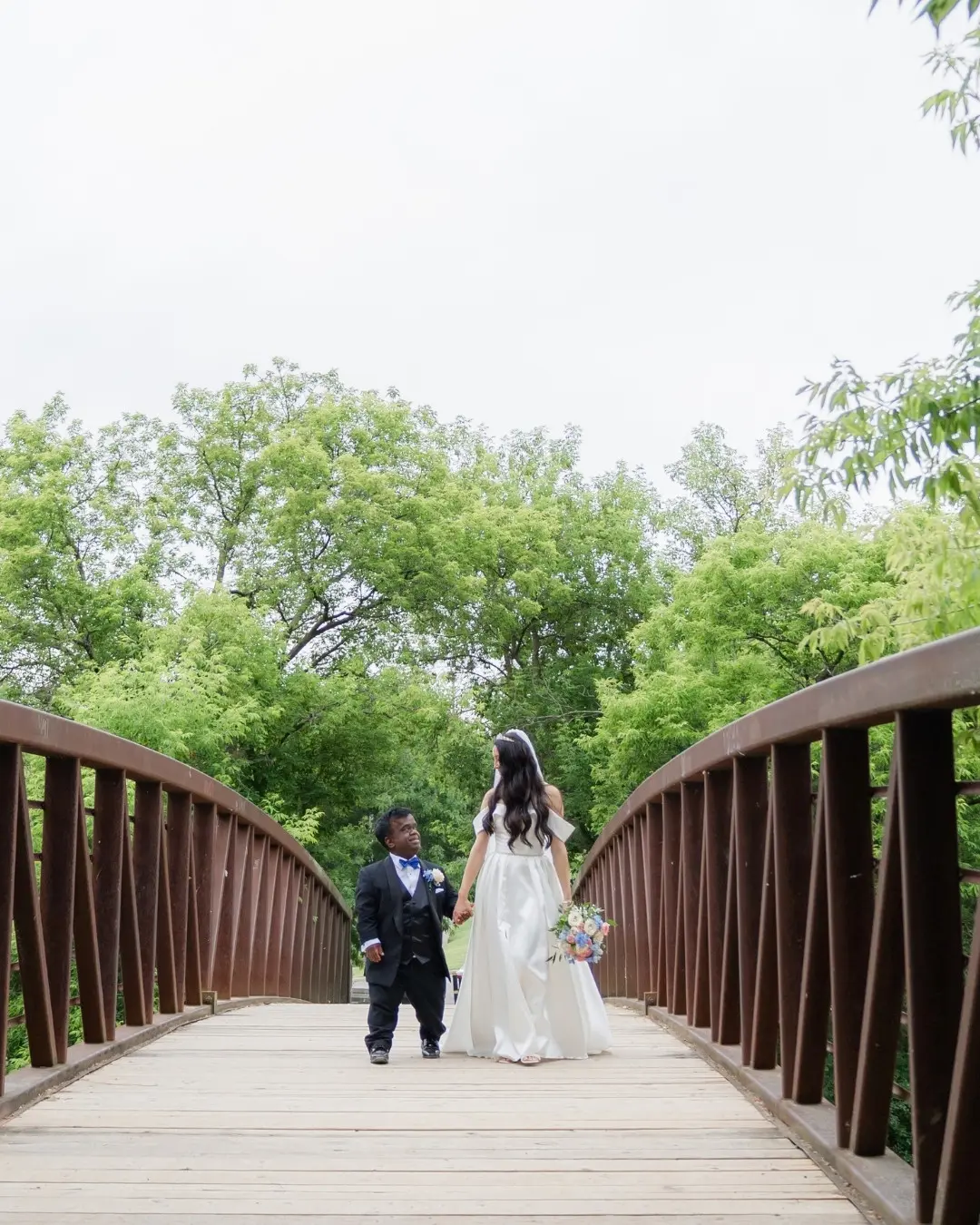 多倫多亞裔企業家安妮塔（Anita Wing Lee）與侏儒症患者提姆（Tim Muttoo）的婚姻引發熱議，兩人 2021 年相識，衝破世俗偏見結為連理，其真實愛情故事與慈善行動備受關注。（來源：anitawinglee@IG）