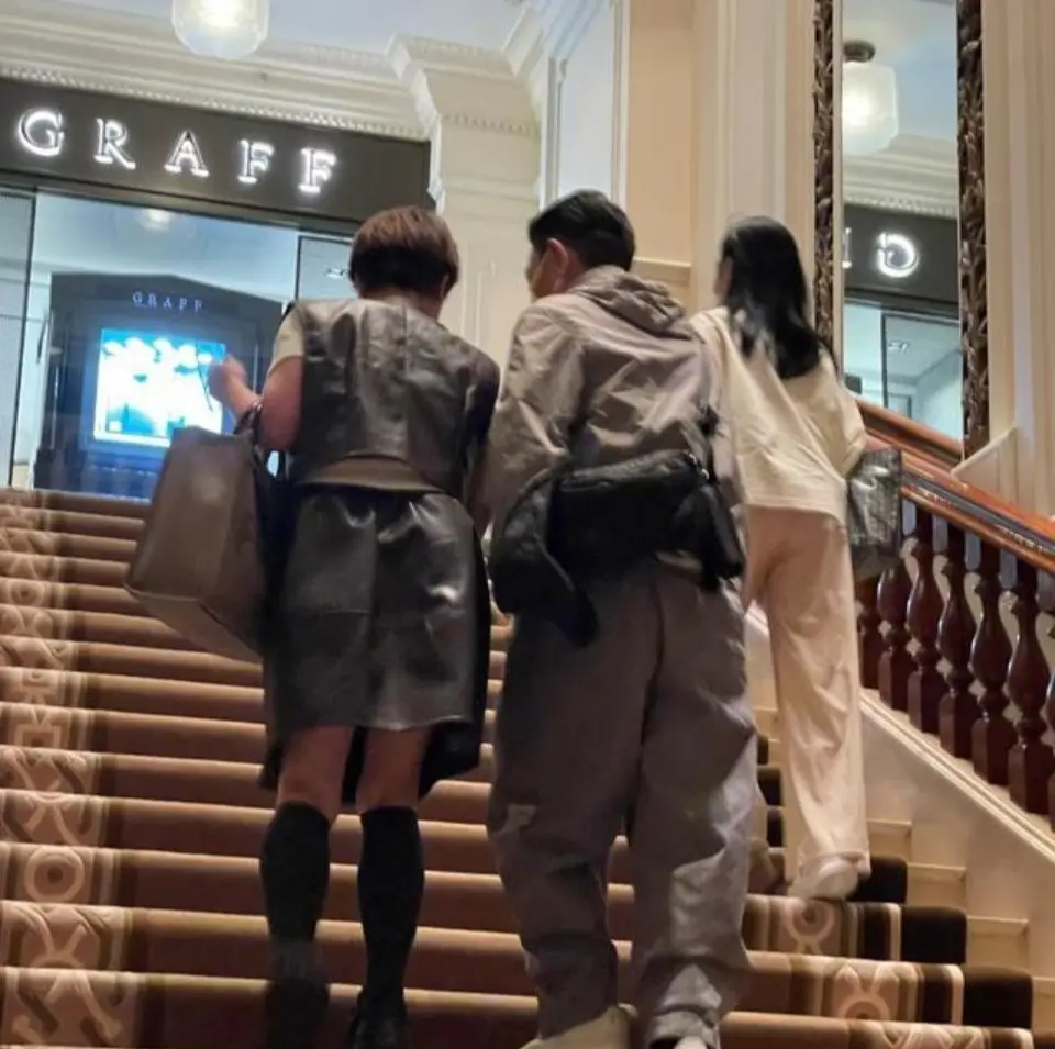事發地點在香港半島酒店附近。兩人沿樓梯上行，身邊有工作人員陪同。劉德華身穿灰色連帽外套、戴口罩、背黑色斜挎包；朱麗蒨一身淺色系穿搭。(圖：风栖旧笺 @微博)