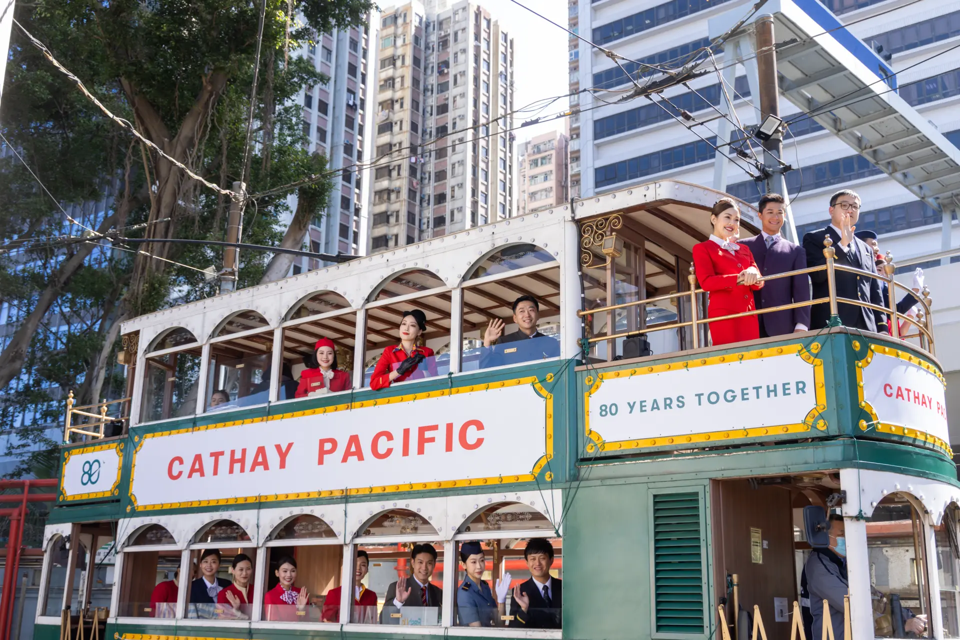 四輛承載著不同年代記憶的電車，緩緩駛過百年軌道，身穿復古制服的機組人員向市民揮手致意，香港的街道瞬間變為流動的航空博物館。(圖：藍莓日報) 