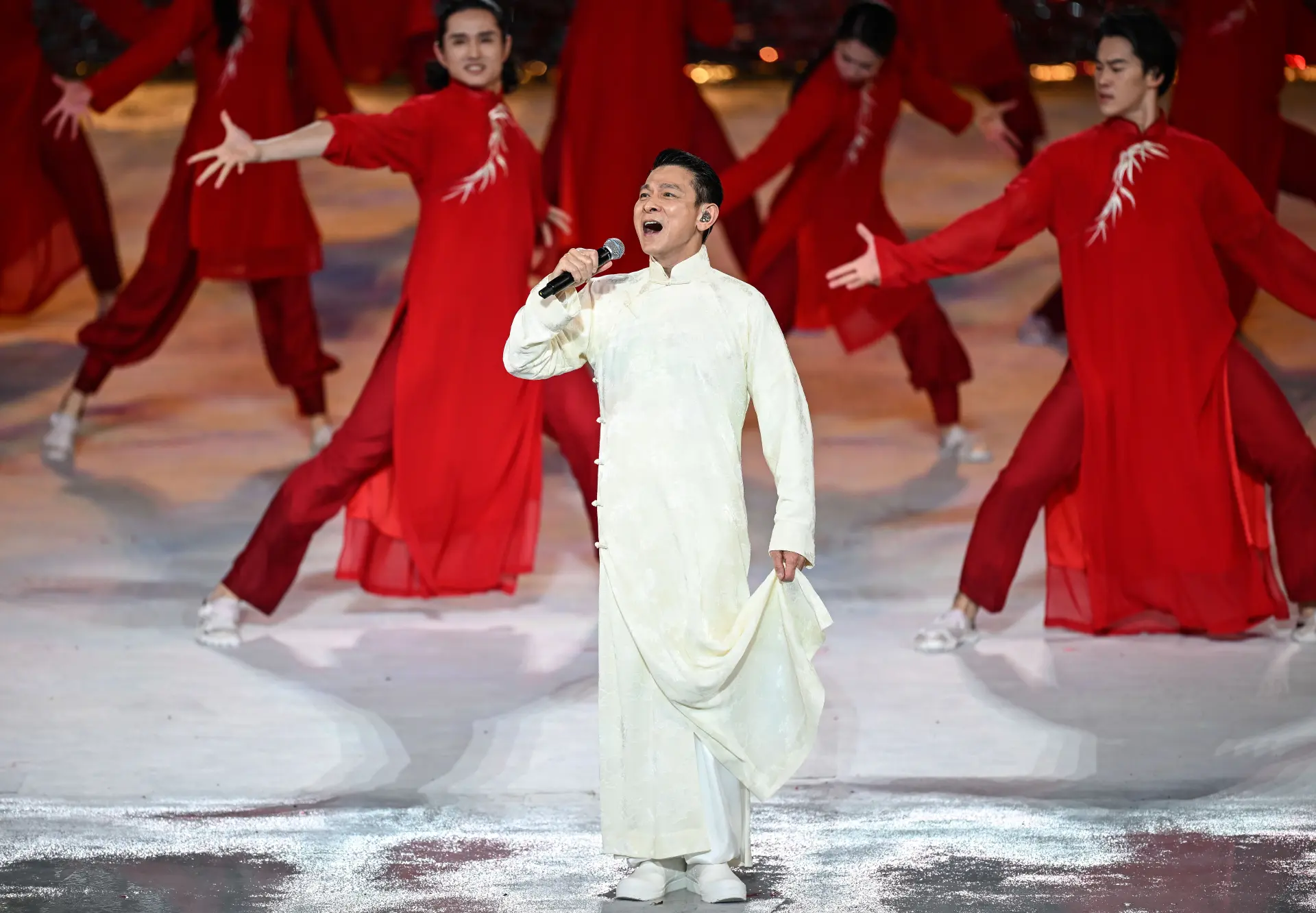 ​壓軸環節由天王劉德華登場，他身穿白色長衫，深情演繹經典歌曲《中國人》。鏗鏘有力的歌詞、激昂澎湃的旋律，搭配劉德華飽含情感的演繹，瞬間將現場氣氛推向最高潮，全場掌聲與歡呼聲經久不息。(圖：新華社)