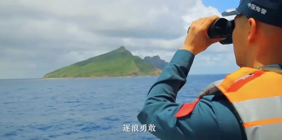 中國海警執法員與釣魚島「同框」，手臂上鮮艷的國旗臂章與釣魚島的海天美景相映成輝