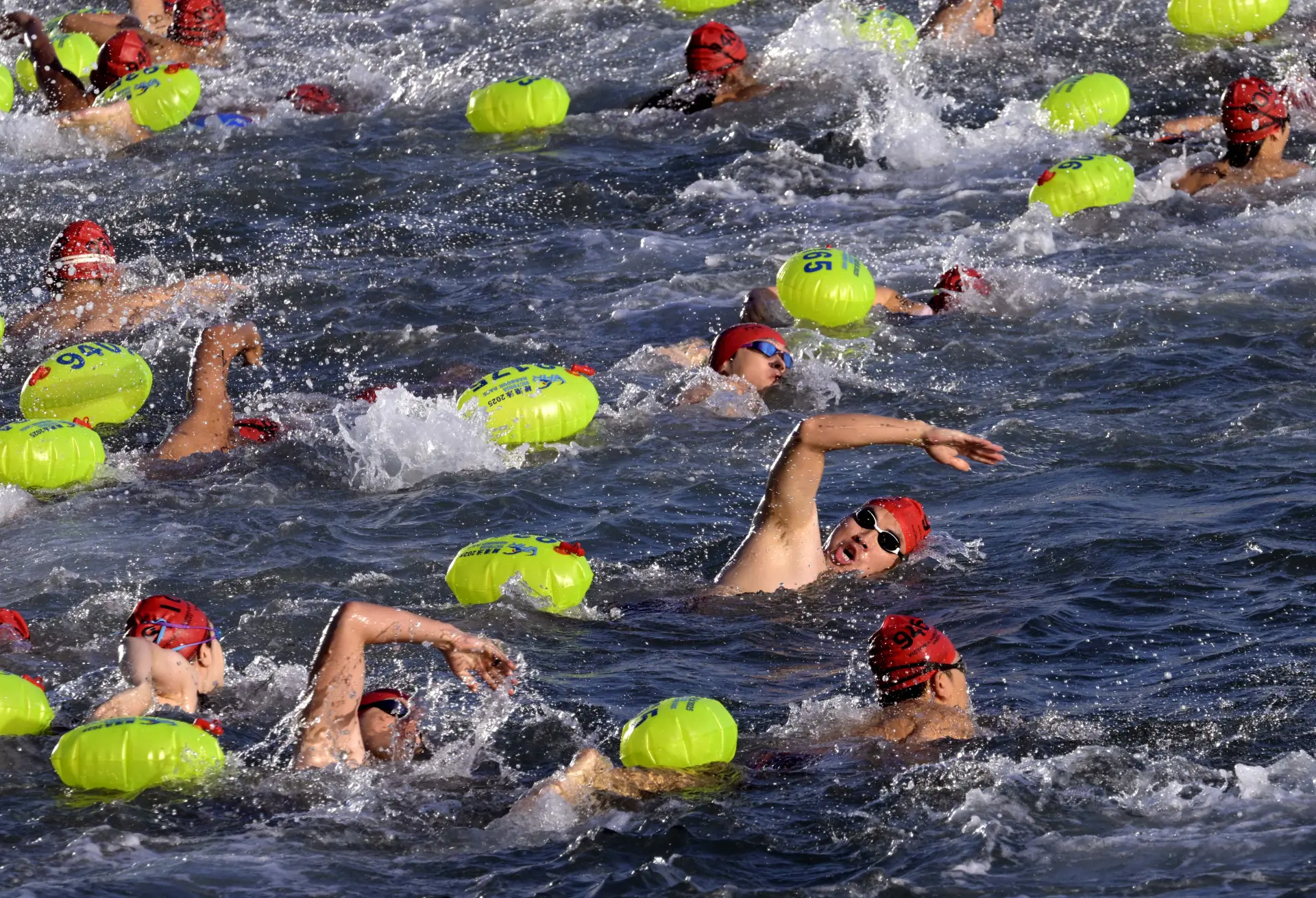 賽事的水質也獲得參賽者一致好評。本地泳手 Dee 稱今年水質明顯提升，游泳時的機油味比往年淡了很多。這背後離不開環保署的諸多努力，其不僅提前加強水質監測、巡查，還聯合海事處清理海漂垃圾，通過多項措施確保水質達到國際比賽嚴格標準。(圖：新華社)