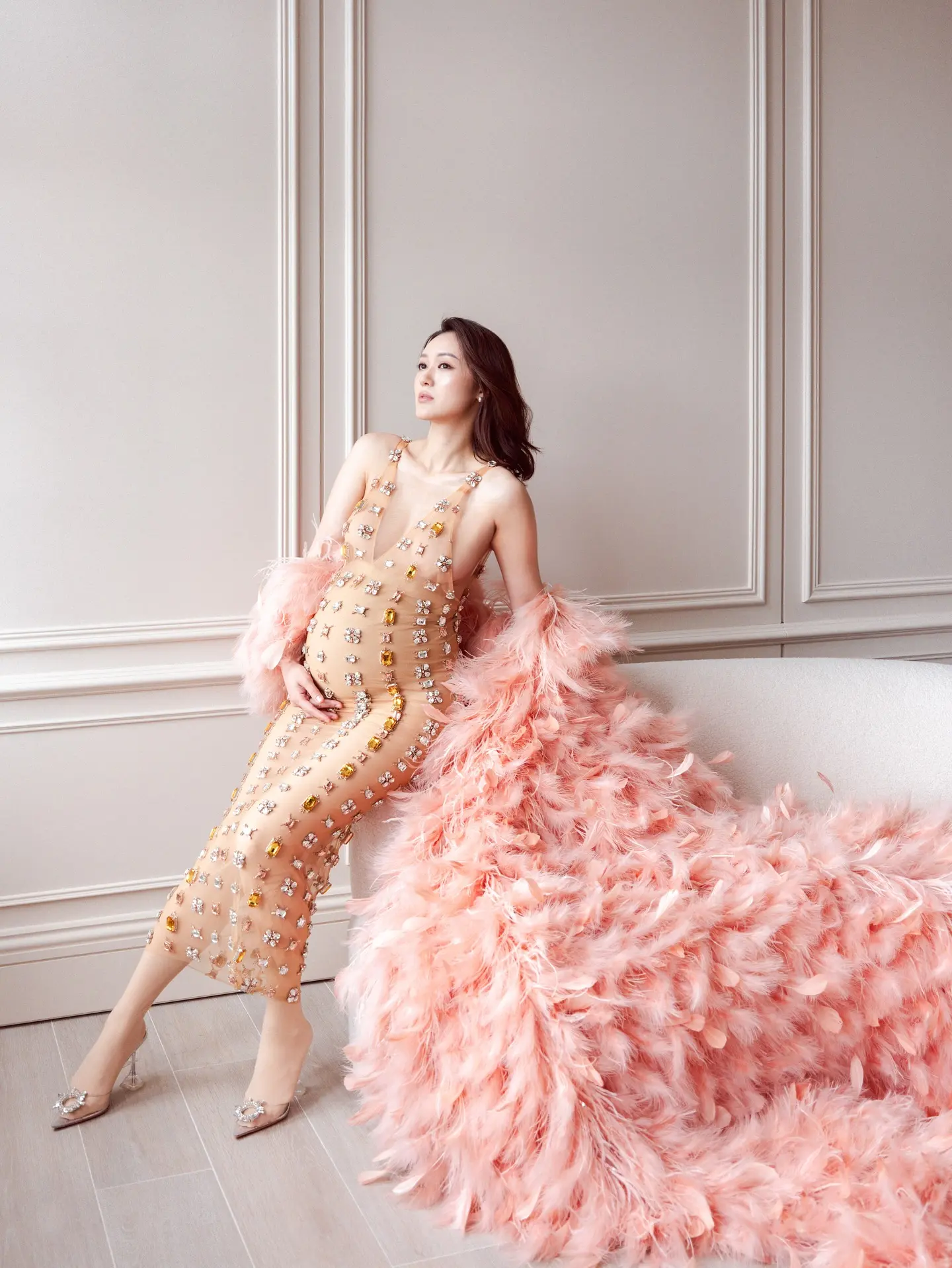 張寶兒身穿裸色 Deep V 連身裙，外搭粉紅色毛毛披肩，驟眼看有透視錯覺，配上 3 寸高跟鞋，四肢依舊纖瘦，僅圓碌碌的巨肚格外顯眼。。(圖：Bowie Cheung 張寶兒@FB)