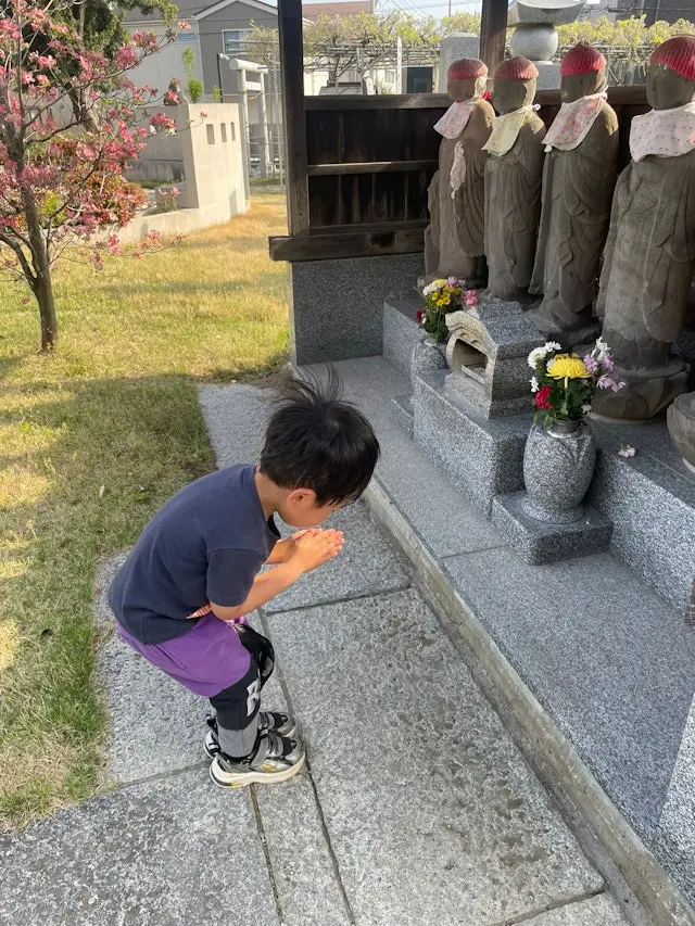 日本一名4歲男童於路邊地藏菩薩前虔誠跪拜祈福，許下希望明天仍是星期天的可愛心願。畫面於社群X爆紅，引發大批網友共鳴集氣，道盡大眾不捨週末的真實心聲。（來源：R453374510@X）
