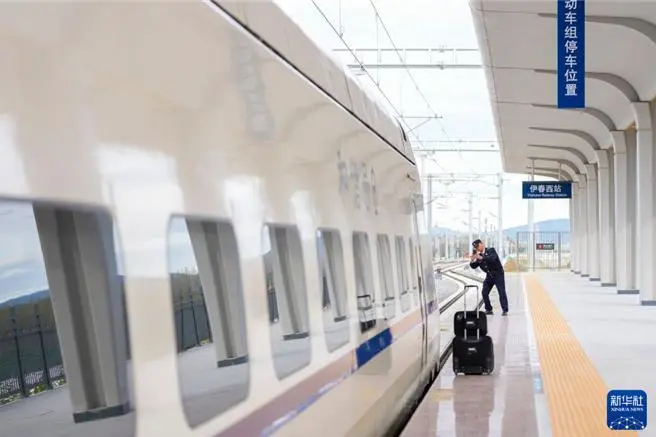 圖為哈爾濱動車段隨車機械師在伊春西站月台巡視檢查。（新華社）