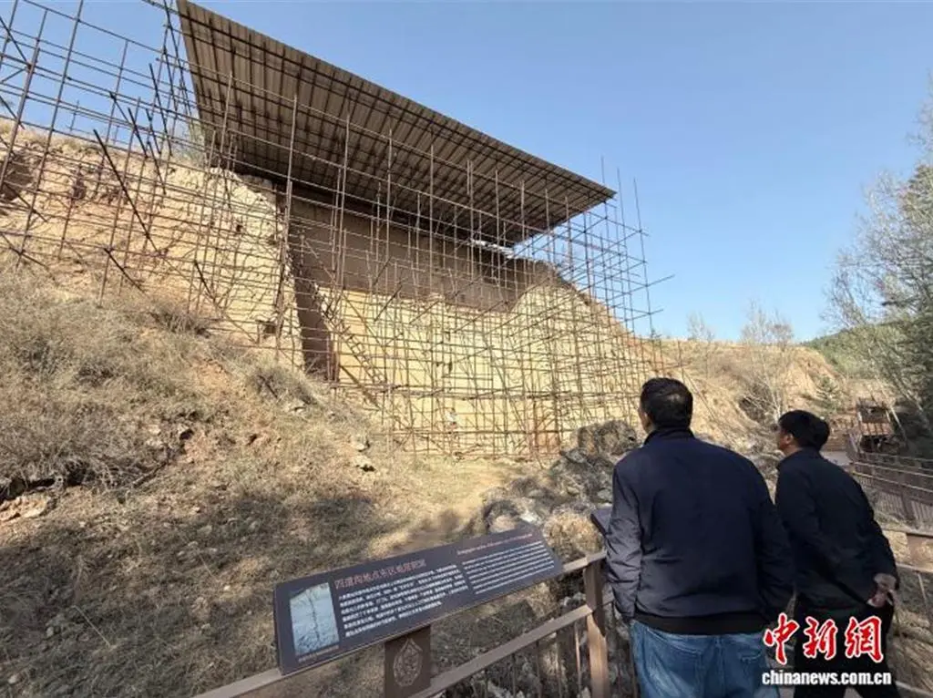汪英華（左一）和同事查看大窯遺址四道溝東區考古發掘剖面點。（中新社）
