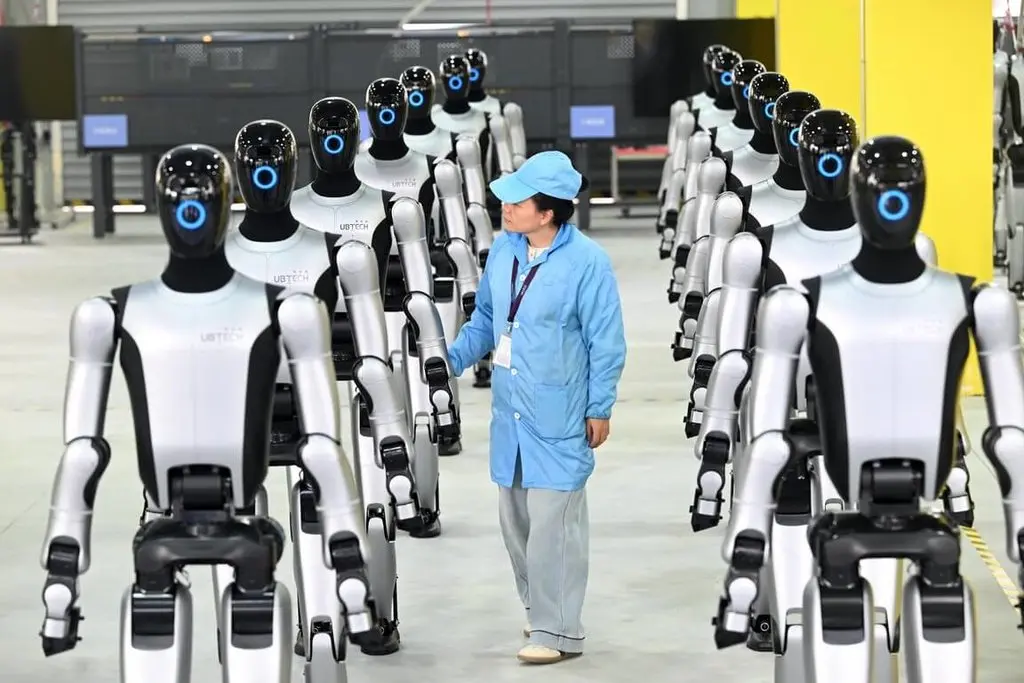 中國人形機器人市場大幅成長，圖為2025年12月26日，廣西柳州第1000台工業人形機器人Walker S2下線，工人正在檢查。（中新社）