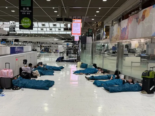 8月14日，成田機場的鐵路交通受到千葉縣暴雨影響而停頓，有旅客獲機場方面派發睡袋在客運大樓內席地而睡。（X/@Thai__Suki）