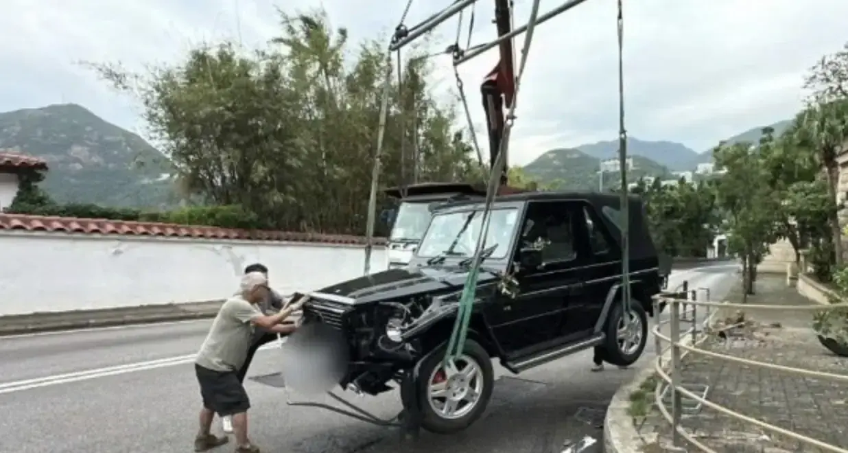 一名女助手趕來負責後續事宜。由於車頭陷入鐵欄內難以拖曳，救援人員特別召來吊臂車，將損毀的越野車吊起後運離現場，期間警方已封鎖部分路段展開調查。(圖：網絡截圖)