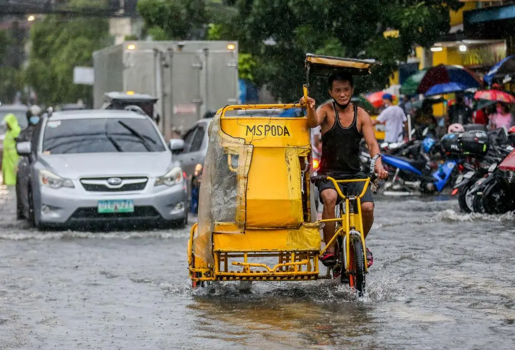 車輛在菲律賓馬尼拉街頭的積水中前行。新華社