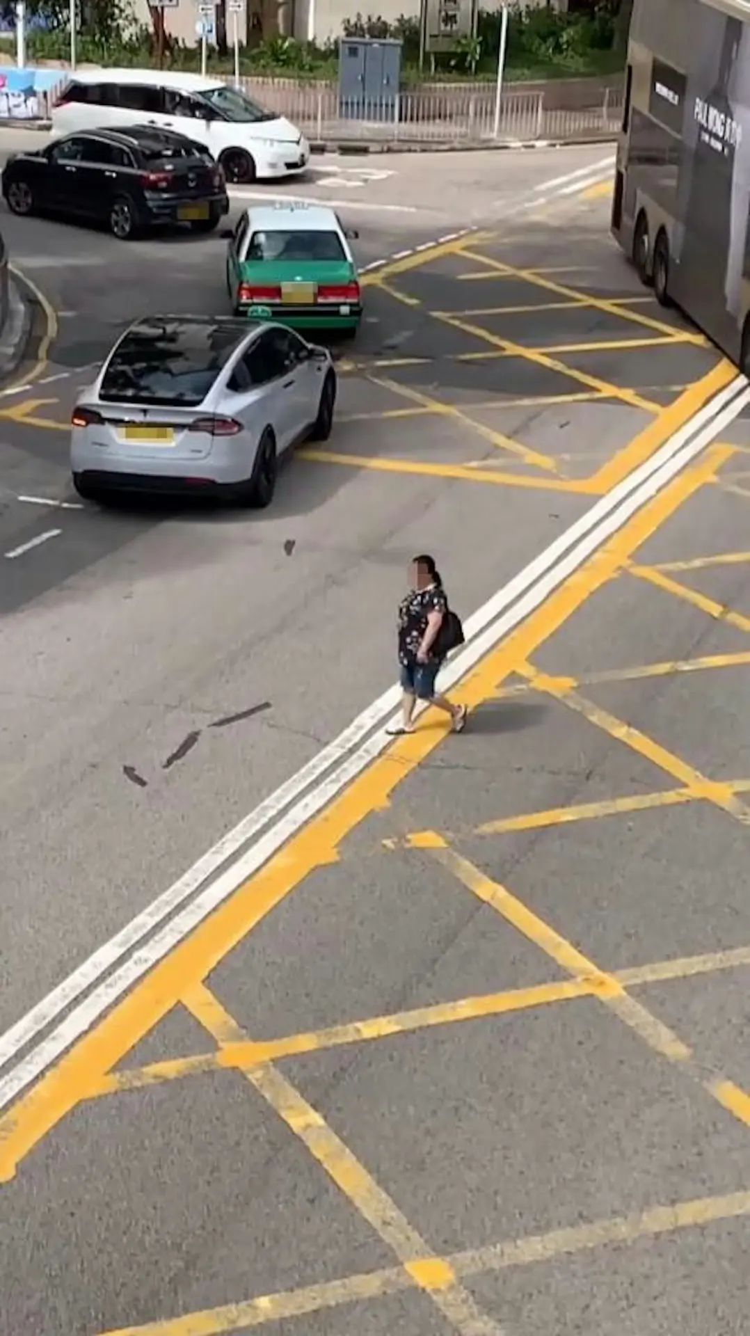 當她走到雙白線位置時，一輛駛近的私家車為避免碰撞，即時減速讓行，險象環生。而婦人對此卻渾然不覺，繼續從容前行。(圖：asiaidiotdrivers@Threads)