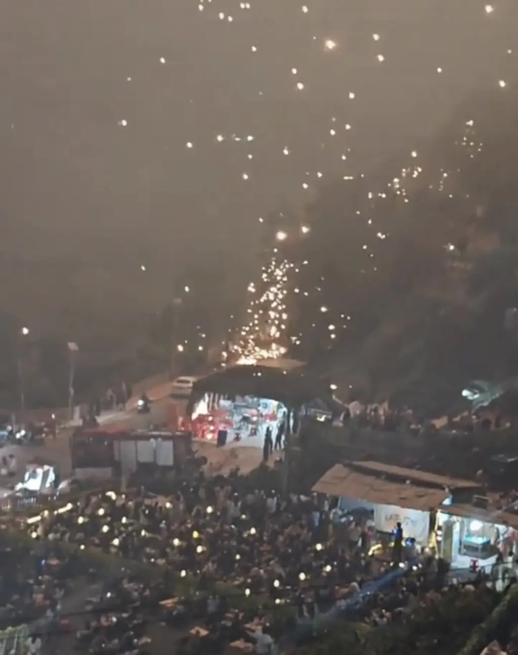 表演尾聲階段，璀璨的煙花火星如流星雨般大範圍飄落，部分墜至附近山坡，瞬間引燃地表枯草，現場可見明顯火線。​(圖：視頻翻攝)