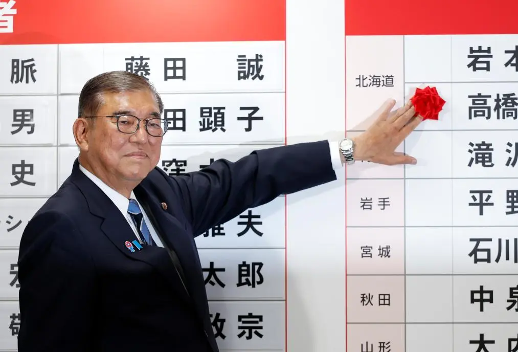 7月20日,在日本東京自民黨總部,日本首相、自民黨總裁石破茂為當選議員貼花。(新華社資料圖片)