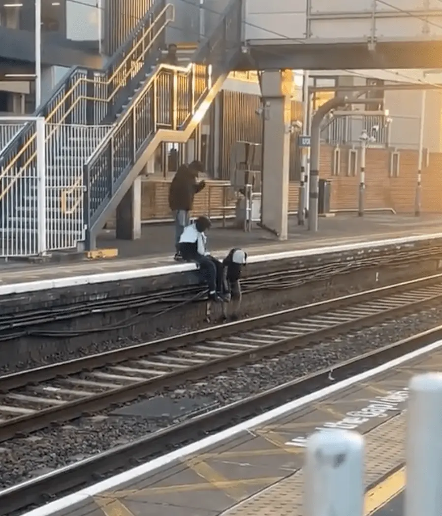 當時一名女子在伊爾福德車站月台上等候列車，突遭一名青年碰撞，手中的手機隨即滑落至下方帶電的鐵路軌道上。(圖：視頻翻攝)