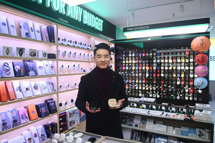 在義烏國際商貿城，一家商鋪負責人展示一款熱銷海外的AI智能穿戴設備（新華社)