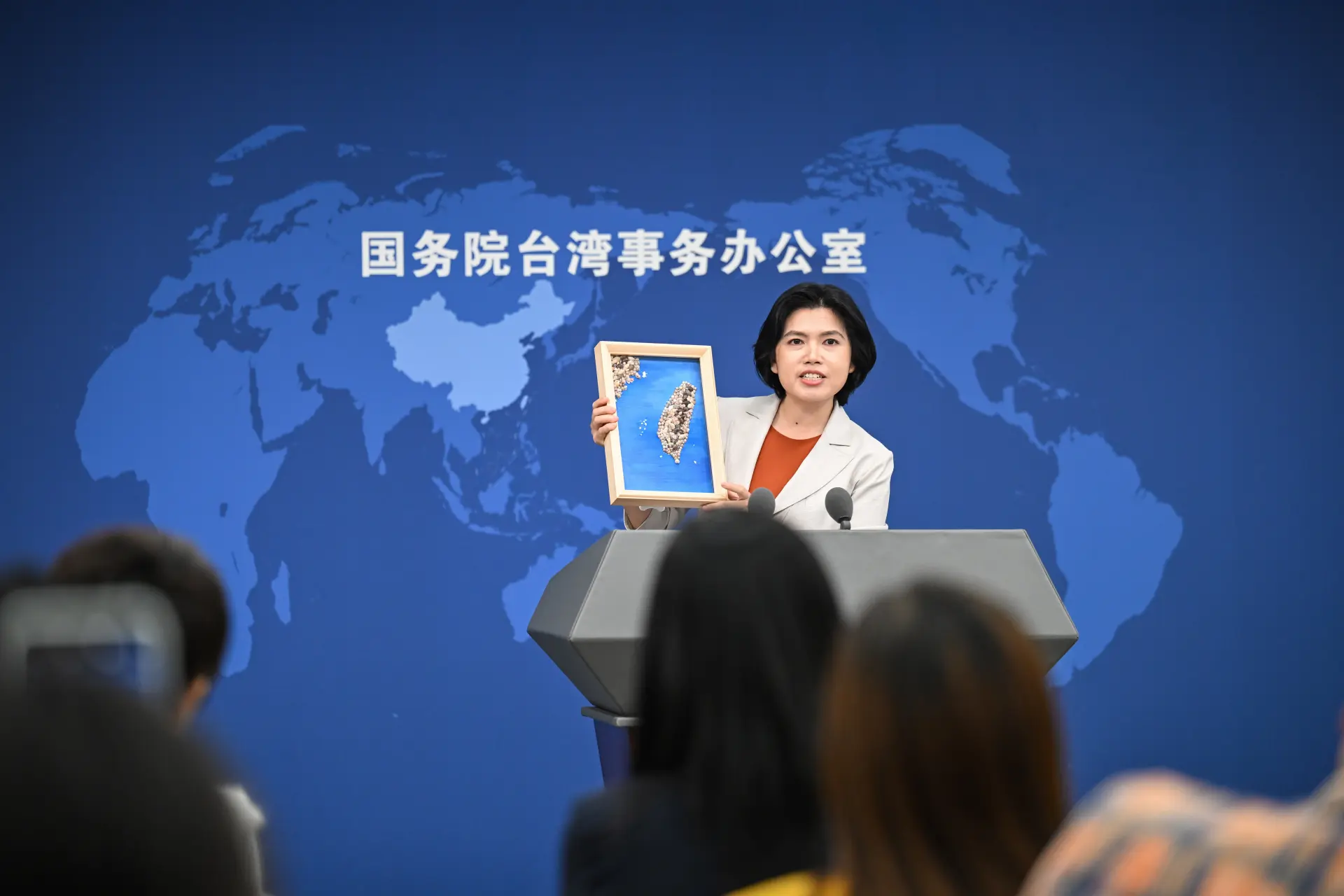 國台辦與朱鳳蓮在發布會上介紹－平潭小學生手工完成的貝雕作品《寶島台灣》。(新華社)