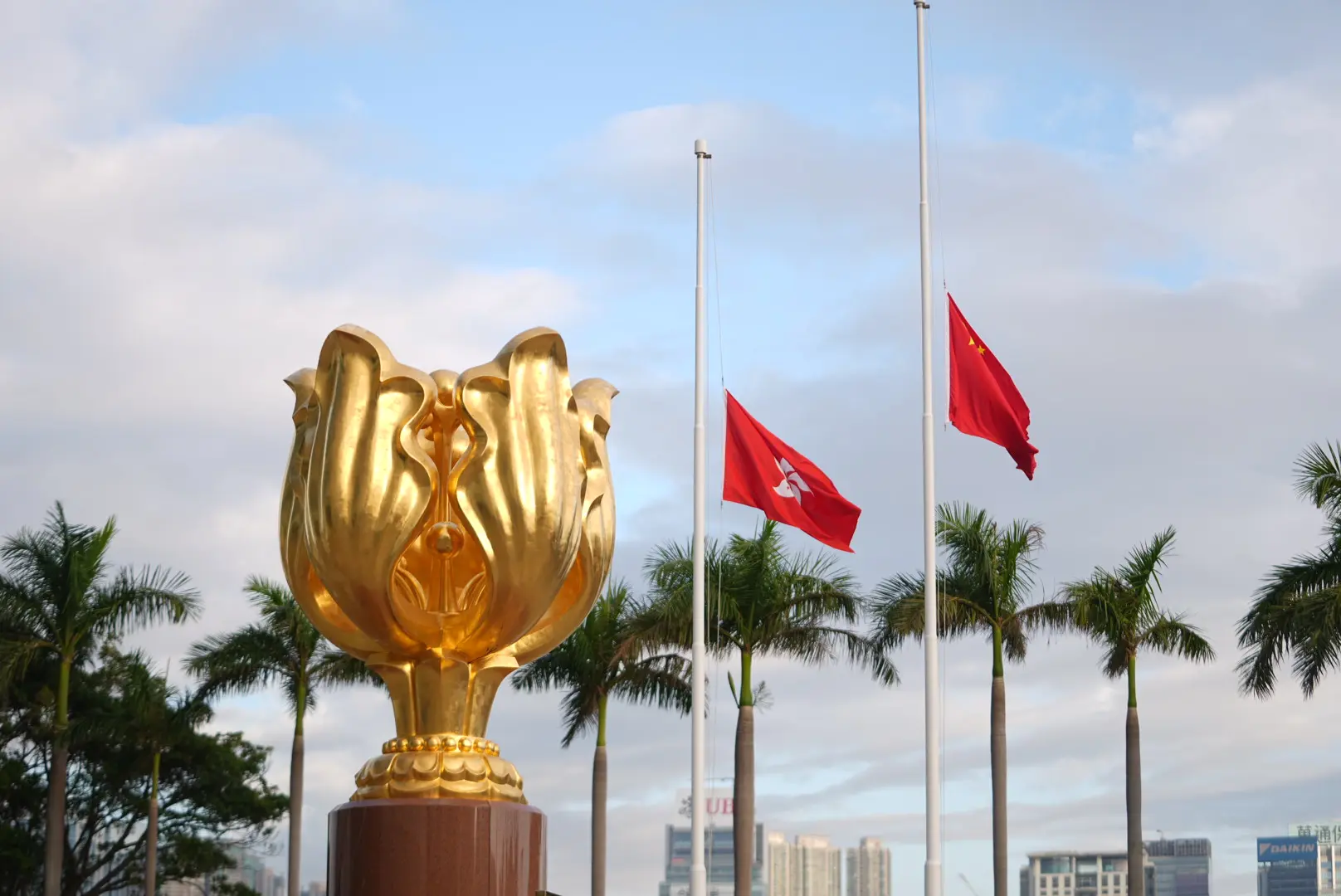 2025年11月29日，香港上空飄揚的國旗與區旗均已降至半空，這座城市正以最莊嚴的方式，緬懷大埔宏福苑五級火中的罹難者。(圖：新華社)