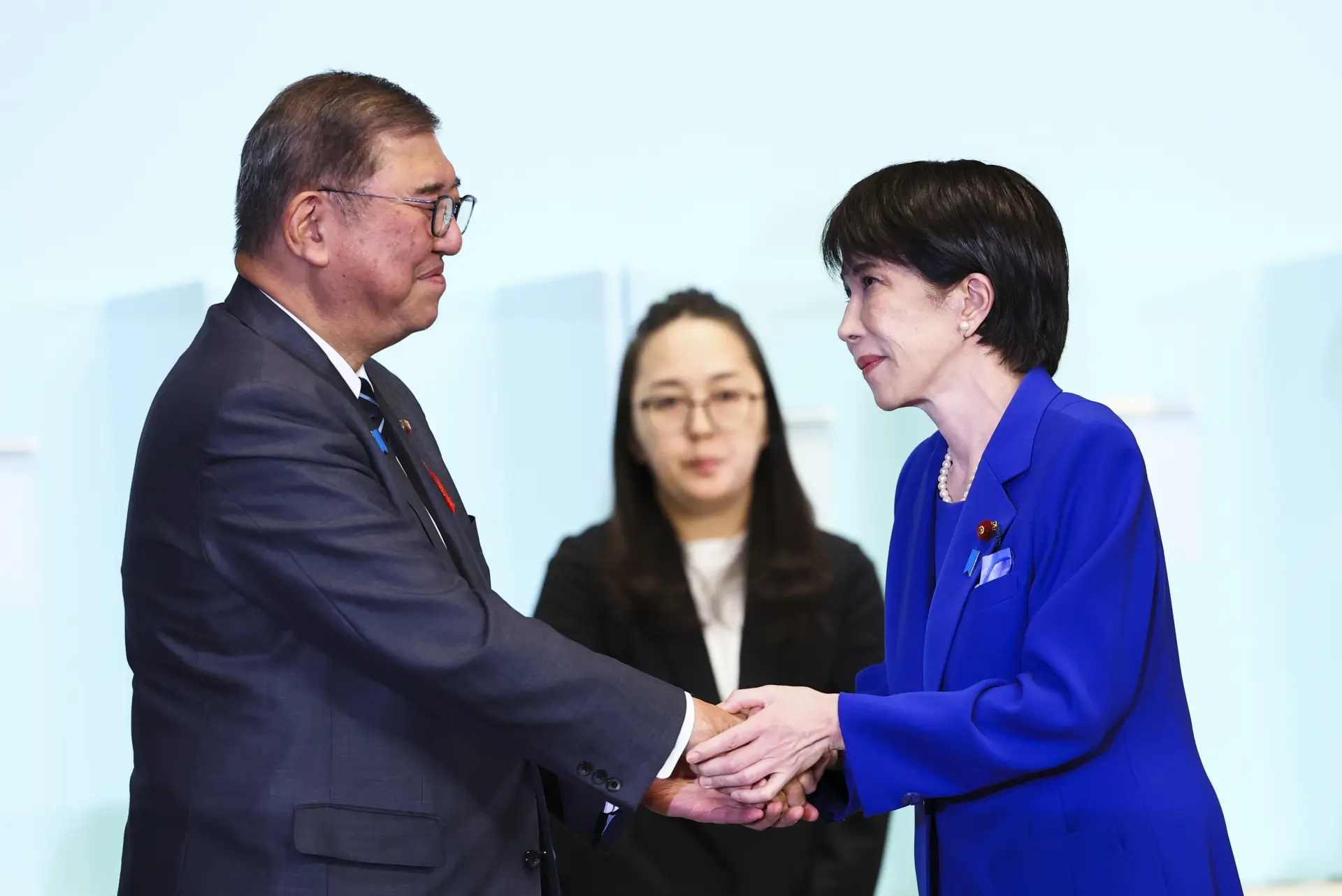 10月4日，在日本東京的自民黨總部，高市早苗（右）在自民黨總裁選舉中勝出後向日本首相、自民黨前任總裁石破茂（左）致意。（圖：新華社）