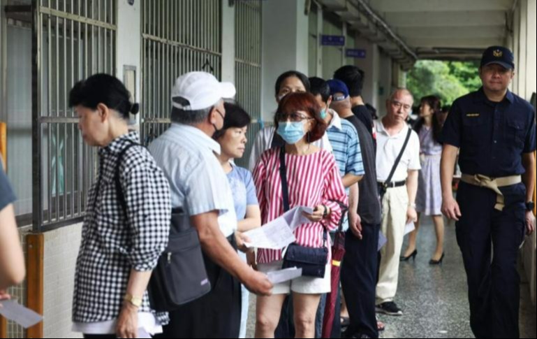 民眾在台北一個投票站排隊投票。(中時)