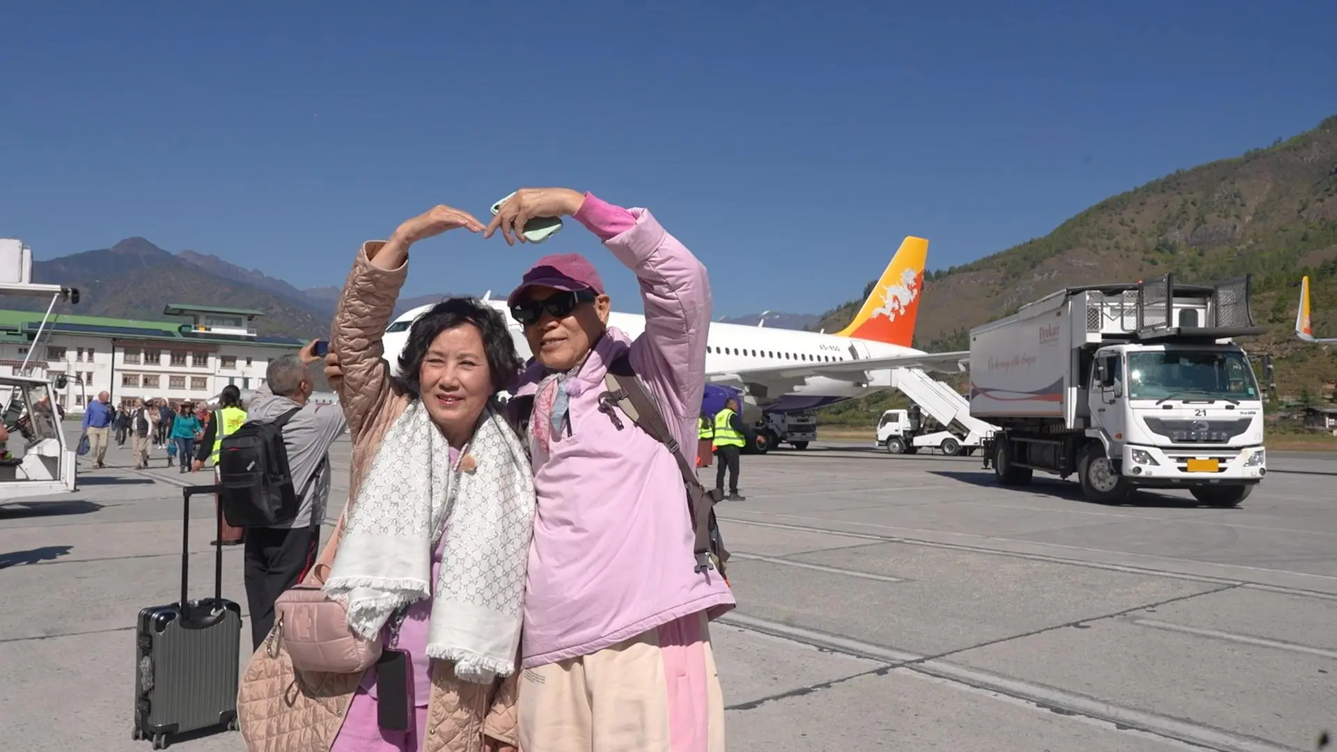 備受關注的無綫台慶綜藝節目《帶阿姐看世界》，在 12 月 10 日晚正式拉開第三站不丹行程的序幕。今次陪伴汪明荃（阿姐）出發看世界的旅伴，正是她的老公羅家英。(圖： TVB)