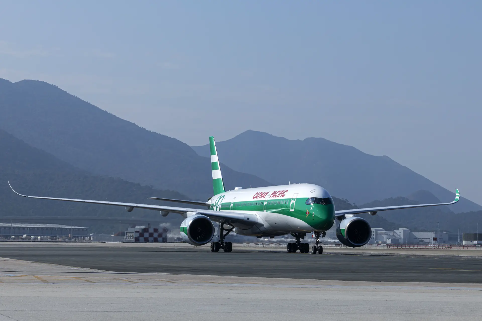 一架披上七十年代經典塗裝的空中巴士A350客機，靜靜停泊在香港赤鱲角機場，其綠白相間的機身在午後陽光下，喚醒了無數香港人的集體記憶。(圖：國泰官網) 