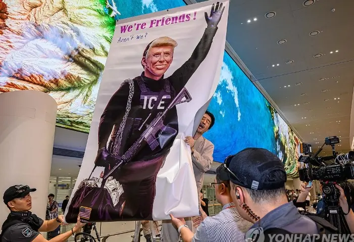 抗議者在機場展示抗議漫畫要求特朗普道歉 (韓聯社)