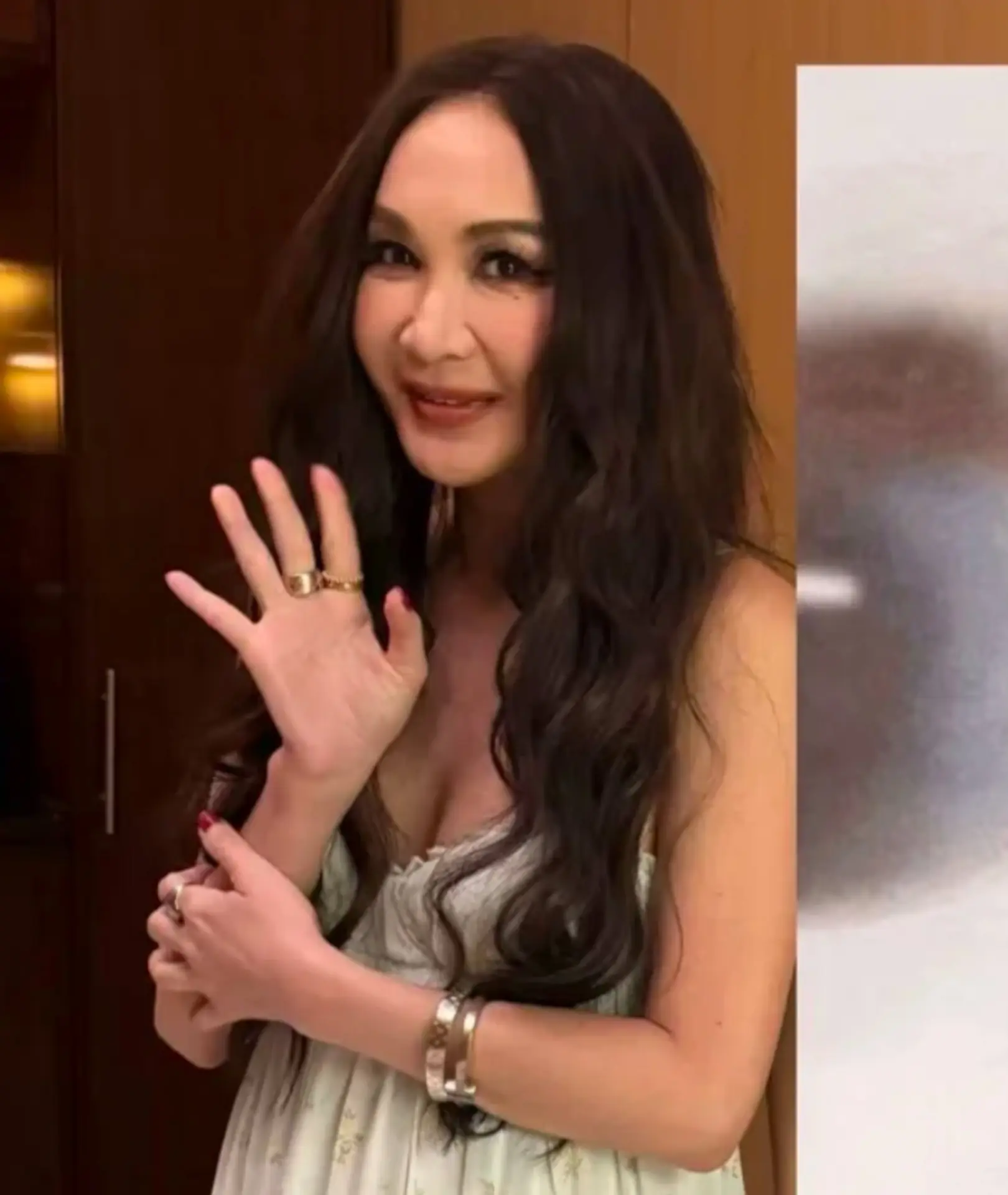 畫面中，溫碧霞身穿簡約吊帶長裙，一頭標誌性長髮隨風飄逸，舉手投足盡是優雅氣質，出眾外形在人群中格外亮眼，甫一入店便吸引全場目光。(圖：小紅書)