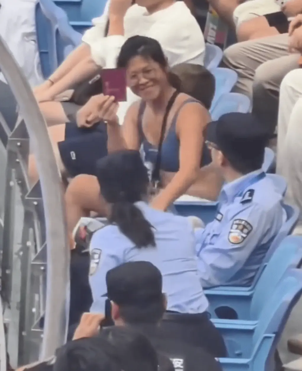 鄰座保安率先示意其安靜，她不僅無視，反而掏出一本暗紅色小本子揮舞，現場網友辨認該物品疑似瑞典護照，她還同步亮出中國大陸身份證，似以身份示威。(圖片：視頻翻攝)