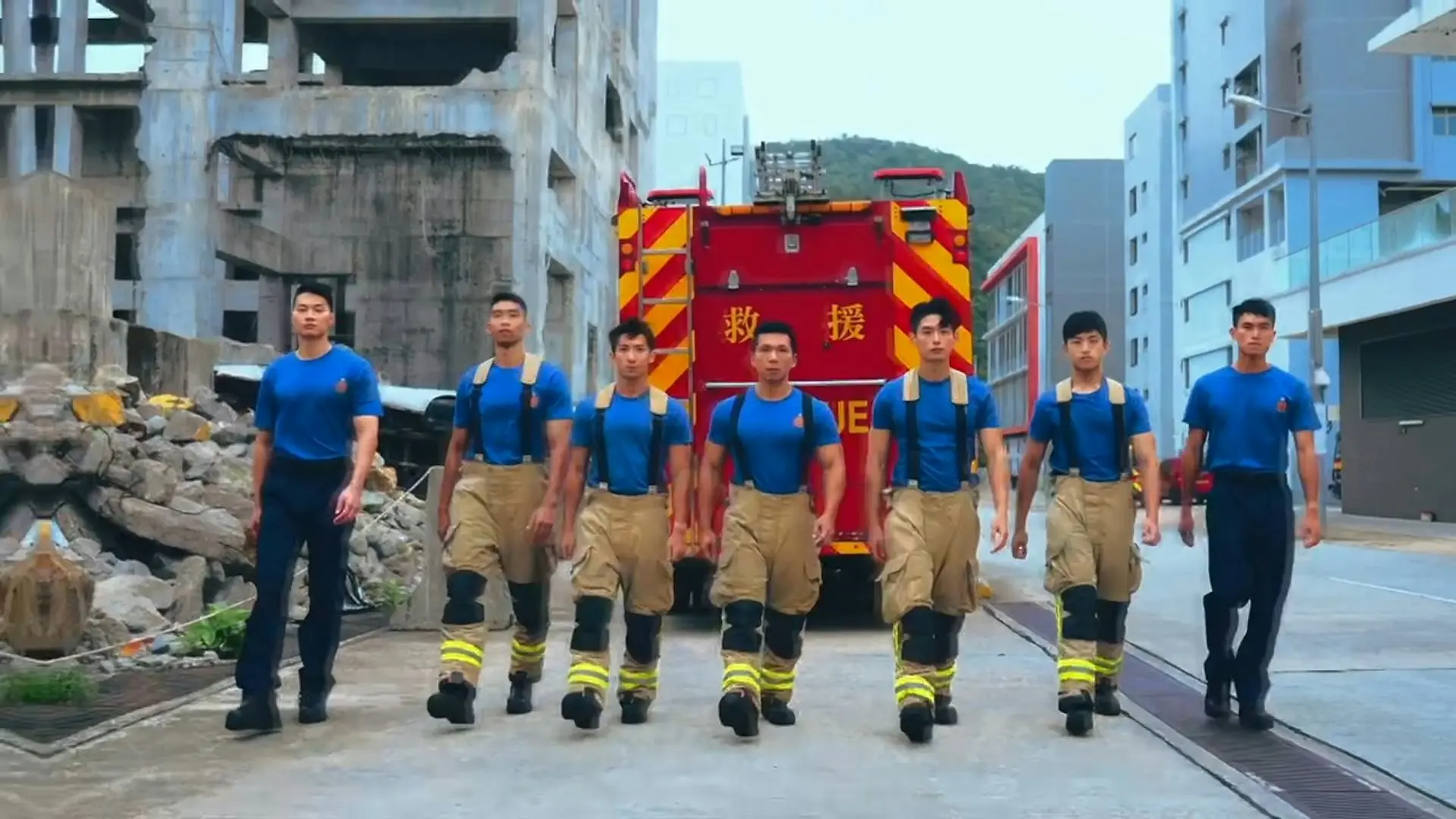 除了整齊劃一的隊形展示，影片中還記錄了消防員做掌上壓、抬着消防喉管、手持機器從瓦礫中步向鏡頭等瞬間，既展現了他們的健碩體魄，更體現出守護香港的堅定決心。(圖：視頻截圖)