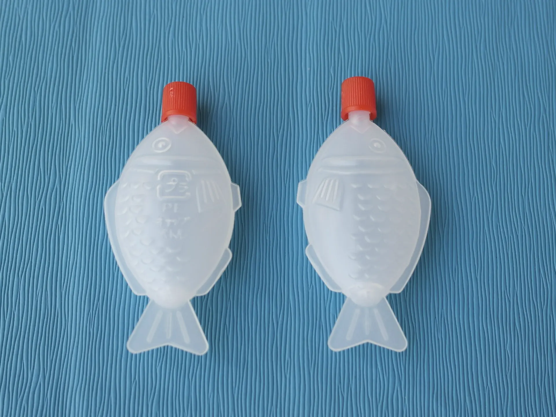 透明圓潤的魚仔豉油樽誕生於日本昭和年間的設計，當初是為了解決傳統碟裝豉油易灑漏、不衛生的問題，魚形造型不僅討喜，擠壓式設計還能精確控制用量，漸漸成為壽司搭配的經典配角。（示意圖來源：alibab）