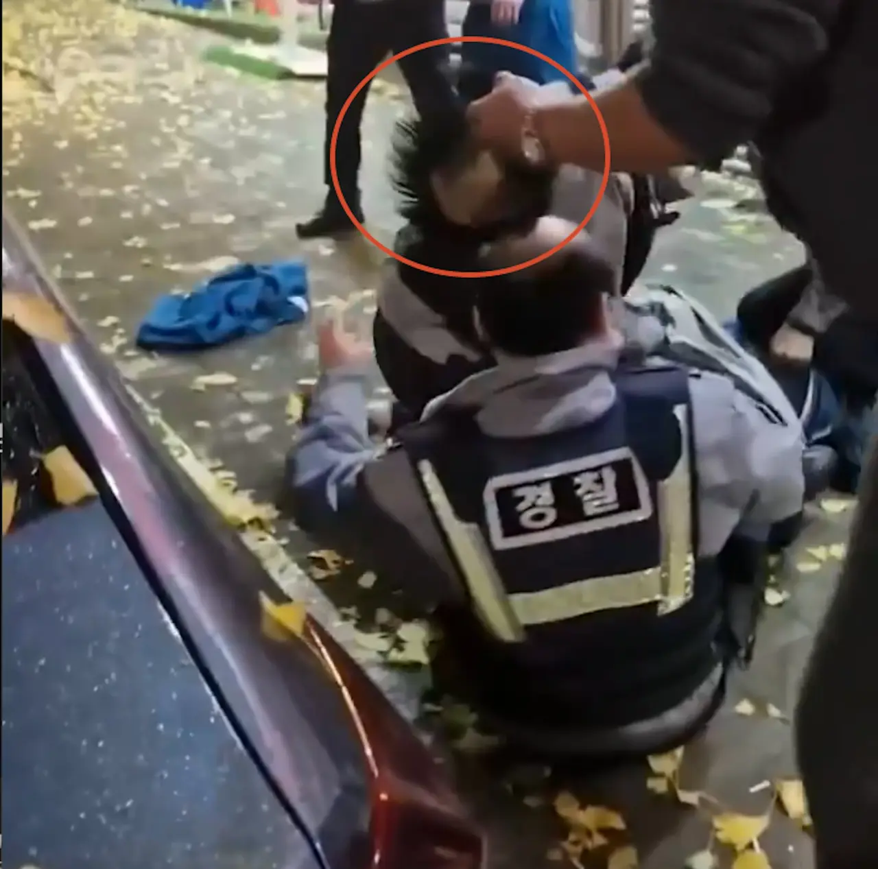 韓國釜山警員街頭合力壓制滋事醉漢時，突發假髮脫落的頭頂意外。一旁路人默默幫忙戴回，嚴肅的執法場面秒變爆笑喜劇反差名場面，影片於網路瘋傳引發熱議。（來源：GONI_GOOD@X）