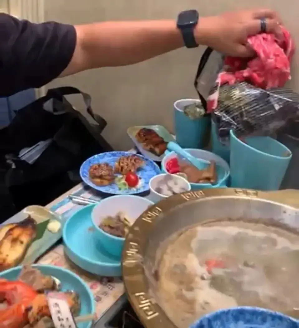 男子先是徒手抓出一大把肥牛放在桌上，期間更因緊張，用碰過生肉的手撥弄頭髮。(圖：視頻翻攝)