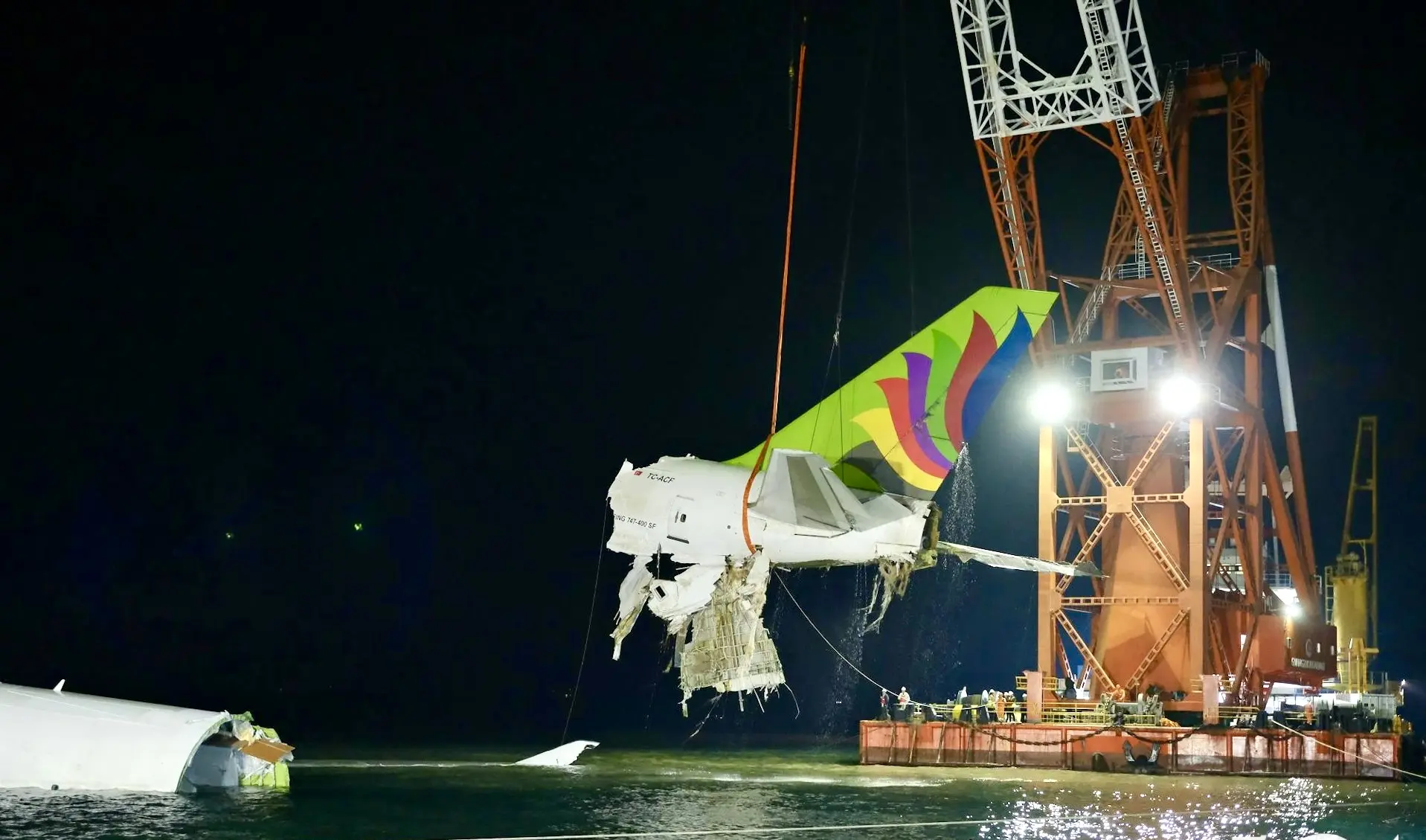 打撈團隊吊起失事貨機機尾，並放在躉船。（機管局提供）